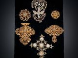 a close up of a black velvet case with a bunch of brooches