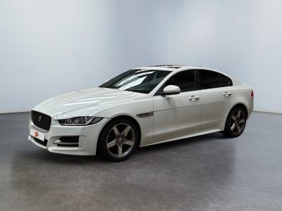 un jaguar blanc garé dans une pièce blanche au sol noir