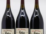 trois bouteilles de vin rouge posées sur une table blanche