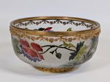 un bol blanc bordé d'or et orné de fleurs