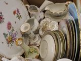 a box full of china plates and bowls on the floor