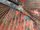 a red and black fan sitting on top of a carpeted floor