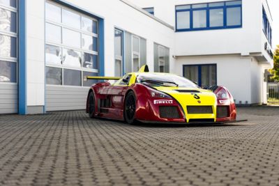 a red and yellow sports car parked in front of a building