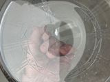 a person holding a piece of plastic in a glass bowl