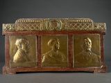 gold - plated casket with four portraits of men in a row