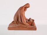 figurine of a woman with a baby in a manger on a marble base