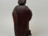 an old wooden statue of a man with a hat on his head