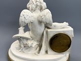 an image of a statue of an angel sitting on a clock