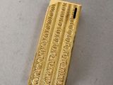 an image of a gold lighter sitting on top of a table