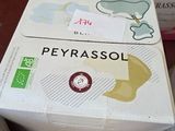 une boîte de Peyrassol posée sur une table à côté d'une tasse de café