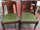 deux chaises en bois avec des coussins rembourrés verts, posées sur un tapis