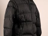 une veste noire posée sur un mannequin, sur fond blanc