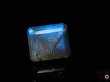 a close up of a square blue stone on a black surface