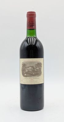 une vieille bouteille de vin rouge posée sur une table blanche
