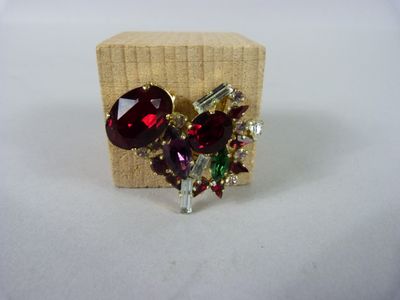 une photo d'une paire de boucles d'oreilles rouges et vertes posées sur un bloc en bois