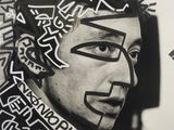 black and white photograph of a man with a face painted with letters