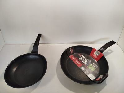 two frying pans sitting on a counter top