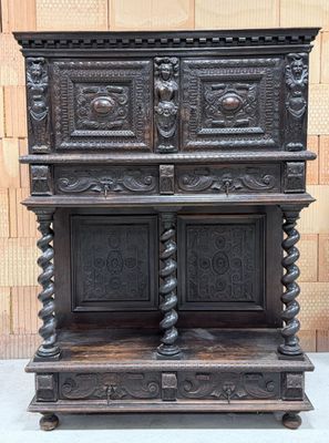 une vieille armoire en bois ornée de sculptures élaborées sur le dessus