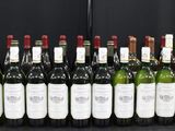 Des bouteilles de vin sont alignées sur une table devant un fond noir
