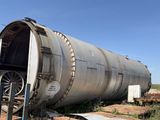 a large metal tank sitting in the middle of a field