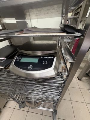 a digital scale sitting on a shelf in a kitchen