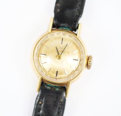 une photo d'une montre-bracelet en or montée sur un bracelet en cuir noir