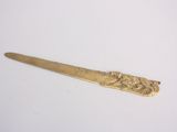 a gold spoon with a design on it on a white surface