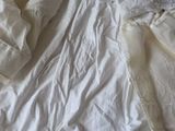 a bed with a white comforter and white sheets on it