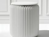 un tabouret blanc sur lequel est posé un papier plié