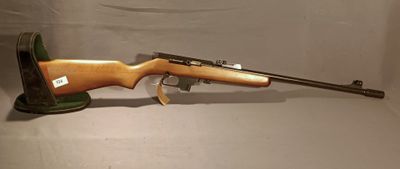 a rifle with a wooden barrel on a stand on a white background