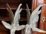 deux oiseaux en métal posés sur une table en bois