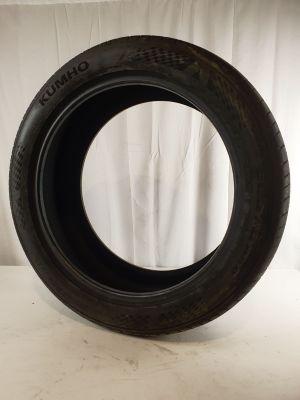 a close up of a tire on a white surface with a curtain in the background