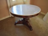a round table with a marble top in the corner of a room