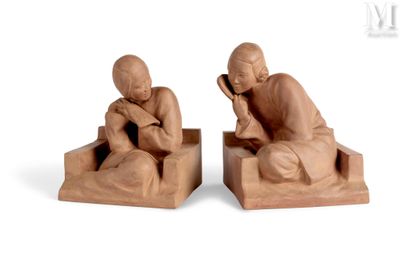 two figurines of a man and a woman sitting on a bench
