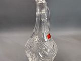 a clear glass vase with a red handle on a table