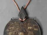 un pendentif noir et doré orné d'un oiseau