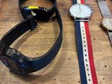 deux montres et un bracelet de montre posés sur une table en bois