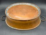 an old copper plate with handles on a black background