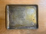 an old metal tray on a wooden table with a yellow substance