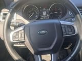 a man sitting in the driver ' s seat of a car
