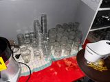 many glasses and a blender sitting on a table