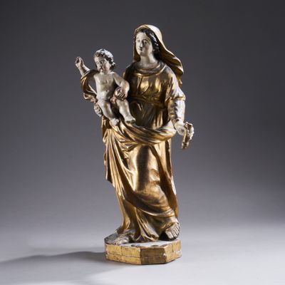 une statue antique en bronze représentant une femme tenant un enfant dans ses bras