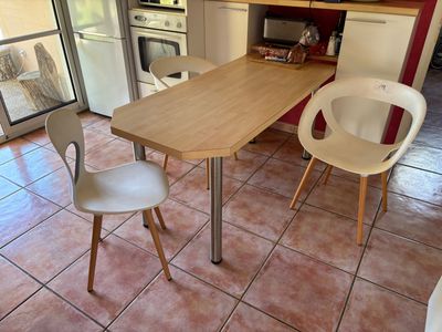 une table et deux chaises dans une petite cuisine