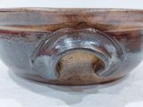 a brown bowl sitting on a table with a white background