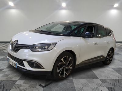 la voiture blanche est garée sur un sol en damier dans le garage