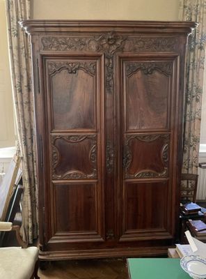 une grande armoire en bois dans le coin d'une pièce