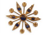 an image of a gold and blue broochle on a white background