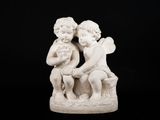 une statue blanche représentant deux enfants assis sur un banc