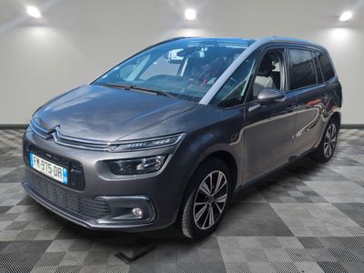 Une Citroën grise est garée dans une pièce au sol carrelé