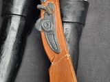 a toy soldier holding a rifle on a black surface